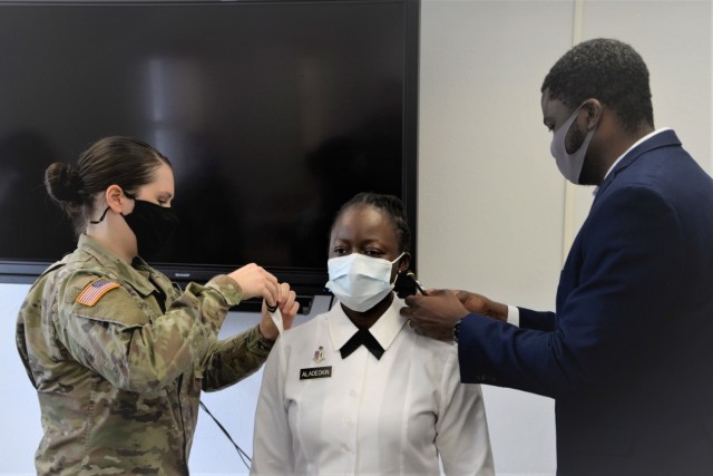 Capt. Victoria Aladeokin, then a 1st Lt., is promoted by her husband, Oluwabunmi “Bunmi” Aladeokin—an operations support assistant with the 14th Military Police Brigade and Capt. Courtney Buchwald, Fort Leonard Wood Army Chief of Public Health Nursing, during her promotion ceremony at the Department of Public Health on Fort Leonard Wood, Missouri Feb. 12.
