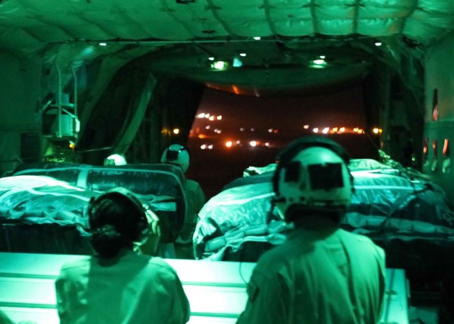 Marine crewmembers conducting a joint airdrop mission with the 1st Theater Sustainment Command-Operational Command Post, watch the last pallet deploy from the back of their C-130J Heracles. The crew dropped pallets of medical supplies, food and other materiel to different sites inside the U.S. Central Command area of operations.  (U.S. Army photo by Staff Sgt. Neil McCabe)