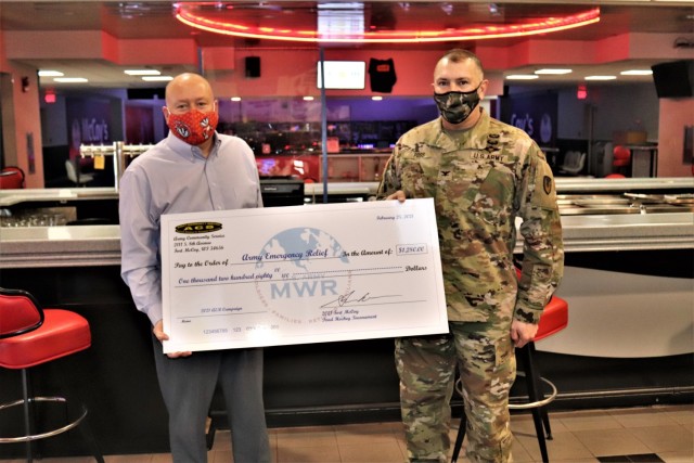 Scott Abell with the Directorate of Family and Morale, Welfare and Recreation and Garrison Commander Col. Michael Poss pose with a $1,280 check being given to Army Emergency Relief (AER) during the 2021 AER Campaign Kickoff Breakfast held Feb. 25,...