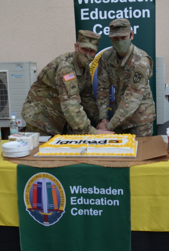 WIESBADEN, Germany -- U.S. Army Garrison Wiesbaden Command Sgt. Maj. Christopher Truchon and Sgt. Jasson Balboa with the 529 Military Police Company cut the education center's cake signifying the launch of the new ArmyIgnitED system, March 8, 2021.