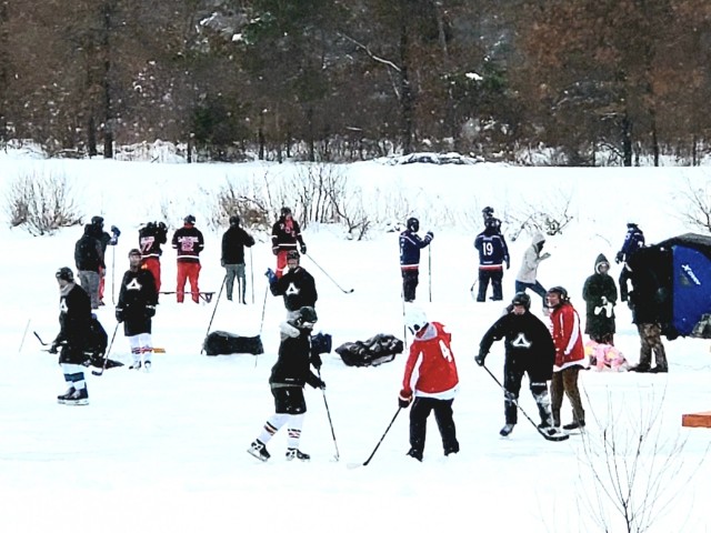 Teams compete in hockey action Feb. 13, 2021, during the Fort McCoy Pond Hockey Tournament on Big Sandy Lake on South Post at Fort McCoy, Wis. The tournament included eight teams from the post and local communities. There were also $1,280 in...