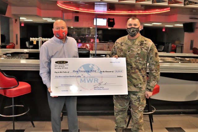 Scott Abell with the Directorate of Family and Morale, Welfare and Recreation and Garrison Commander Col. Michael Poss pose with a $1,280 check being given to Army Emergency Relief (AER) during the 2021 AER Campaign Kickoff Breakfast held Feb. 25,...