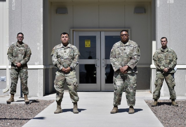 The Fort Bliss OR-MTC team pauses briefly following a building inspection near Camp McGregor, Fort Bliss, Texas, March 10, 2021. Pictured from left to right Staff Sgt. Nefty De La Rosa, OR-MTC base camp noncommissioned officer, 1st Lt. Juan Mendoza, OR-MTC officer in charge, Master Sgt. Edward Scott, OR-MTC noncommissioned officer in charge, and Sgt. Paul Askedall II, OR-MTC base camp noncommissioned officer. The OR-MTC team is responsible for providing quality of life troop sustainment for units conducting mobilization validation certification training, and Pre-Mobilization/Exercise Training (PMET).  (U.S. Army photo by Capt. Brandon Fambro)