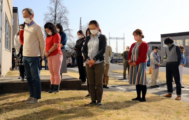 U.S. Army Garrison Japan employees stand outside the headquarters building at Camp Zama, Japan, at 2:46 p.m. March 11, in commemoration of the magnitude 9.0 earthquake that struck off the eastern coast of Japan 10 years ago.