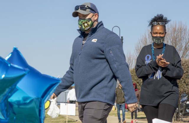 U.S. Army Soldier Sgt. 1st Class Jewel Lott, a colon cancer survivor and awareness organizer assigned to the 120th Infantry Brigade, Division West, walks across the finish line with one of her supporters, during a colon cancer awareness walk on March 6 at Lions Club Park, Killeen, Texas. While March is colon cancer awareness month, Lott has started a new journey of supporting her community by organizing an annual walk for colon cancer. (U.S. Army Reserve Photo by 
Staff Sgt. Erick Yates)