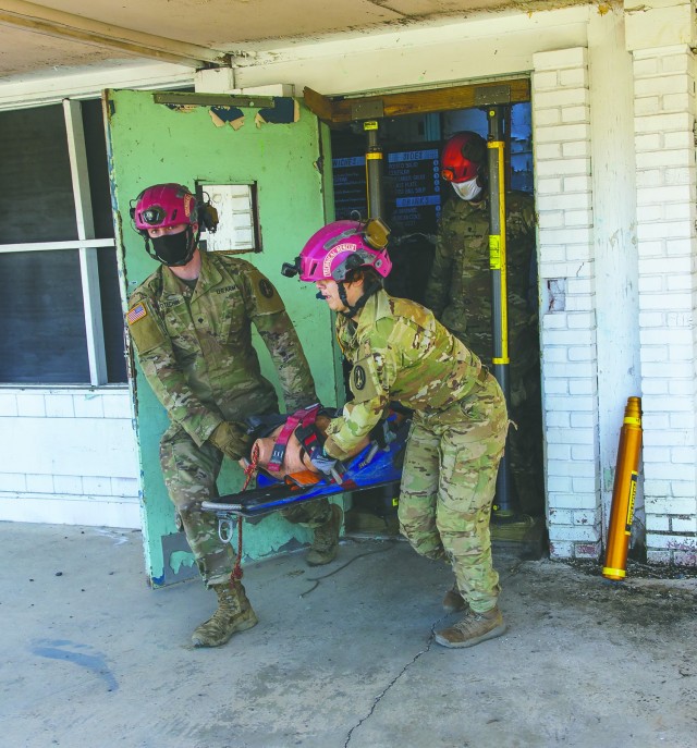 Spc. Brendan Potechin, left, and Spc. Vanessa Toro evacuate a helicopter crash victim as the 911th Engineering Techncial Rescue Company holds a competition for Rescuer of the Quarter at the Lorton Training Site, Feb. 25.