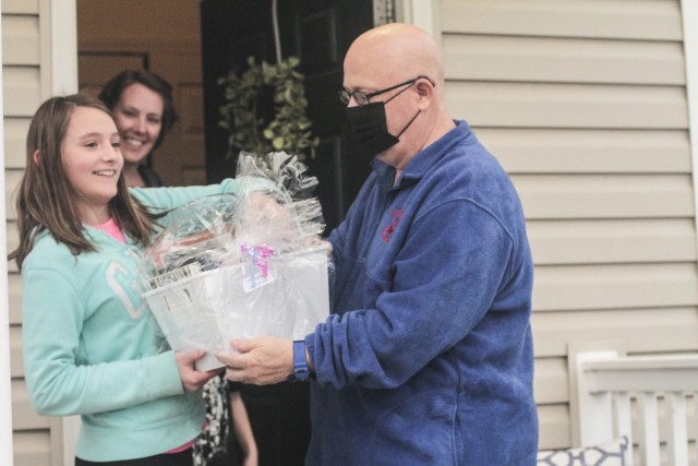 Zoe Callan, fifth grade student at Andre Lucas Elementary School, smiles with glee March 5 as Steven Gardner, the school’s principal, hands her a gift basket full of books. Zoe’s mom, Tamara Callan, watches as the excitement unfolds.