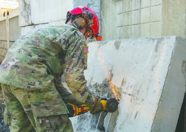 Spec. Jonathan Best, a rescuer wth the 911th Engineering Techncial Rescue Company, cuts rebar to create a hole large enough to climb through, during a competition for Rescuer of the Quarter at the Lorton Training Site, Feb. 25.