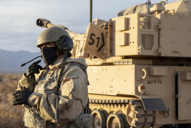 Sgt. Keana Hodgemire, assigned to 2nd Battalion, 3rd Field Artillery Regiment, 1st Brigade Combat Team, 1st Armored Division, stands outside an M-109 Paladin waiting for a fire mission during an artillery qualification training exercise on the...