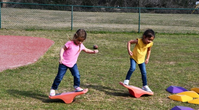 Piper Smith, 3, and Kayla Morris, 3, have fun trying to balance while playing outside