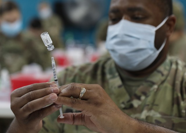 Army Reserve Sgt. Richard Liggans, a resident of Buffalo, New York, deployed to Camp Arifjan, Kuwait, with the 228th Combat Support Hospital, where he serves at the noncommission officer-in-charge of the camp's Troop Medical Clinic, loads a syringe with the Janssen Biotech COVID-19 vaccine at the camp's March 13, 2021 rollout of Operation Med Spear. Unlike other vaccines, the Janssen vaccine is administered with just one shot, not two. (U.S. Army photo by Staff Sgt. Neil W. McCabe)