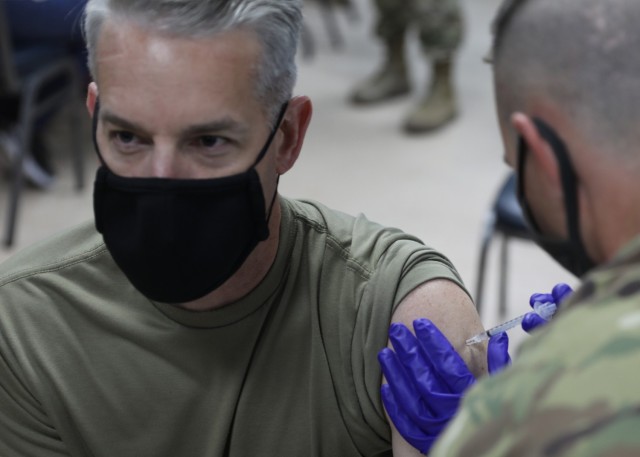 Army Col. John J. Herrman, the commander of Area Support Group-Kuwait, looks away as he receives his Janssen Biotech COVID-19 vaccine at the March 13, 2021 rollout of Operation Med Spear at Camp Arifjan, Kuwait. "It is one of our highest priorities here at ASG-Kuwait," Herrman said. "Without the vaccine, all we're going to do is continue to go up and down in terms of COVID-19 spikes." (U.S. Army photo by Staff Sgt. Neil W. McCabe)