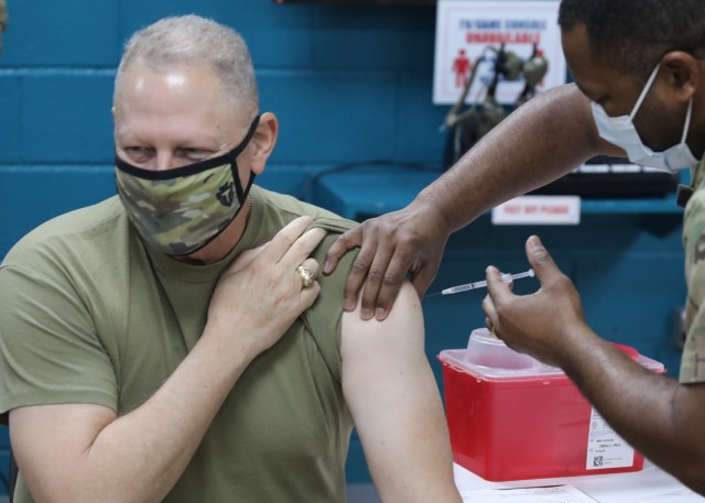 Maj. Gen. Patrick Hamilton, the commanding general of Texas National Guard's 36th Infantry, deployed to Camp Arifjan, Kuwait, as the commanding general of Task Force Spartan braces for his one-dose Janssen Biotech COVID-19 vaccine during the camp's March 13, 2021 rollout of Operation Med Spear. Unlike other COVID-19 vaccines, the Janssen vaccine does not have to be frozen in transit, which makes it easier to distribute to Soldiers deployed overseas. (U.S. Army photo by Staff Sgt. Neil W. McCabe)