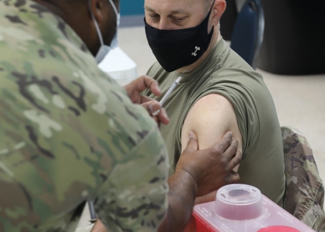 Army Reserve Brig. Gen. Justin Swanson, deployed to Camp Arifjan, Kuwait, as the deputy commanding general of 1st Theater Sustainment Command, follows the syringe with his eyes moments before he receives the Janssen Biotech COVID-19 vaccine at the camp's March 13, 2021 rollout of Operation Med Spear. Swanson is just one of the general officers and other senior leaders, who stepped forward to demonstrate their confidence in the vaccine. (U.S. Army photo by Staff Sgt. Neil W. McCabe)