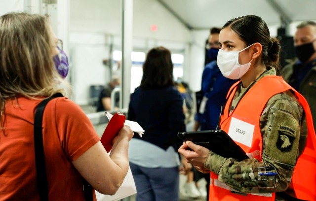 Pfc. Yasmin Aguilar, a combat medic with the 426th Brigade Support Battalion at Fort Campbell, Kentucky, assists lines of seniors, health care workers, and medically vulnerable people last week, at a COVID-19 mass vaccination site just outside the...
