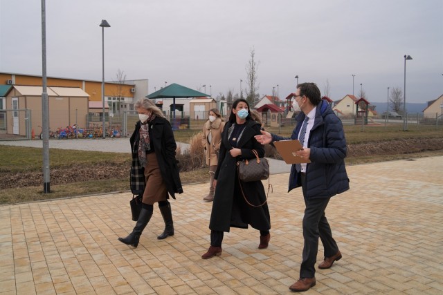 The tour continues through the Netzaberg community, USAG Bavaria&#39;s largest housing area, to view the local chapel, school grounds and child care services, March 11, 2021. To the right, Deputy Commander Howard Johnston continues to brief Angela...