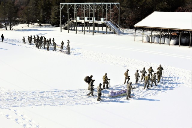 Students in Cold-Weather Operations Course class 21-04 complete field training pulling ahkio sleds of equipment on snowshoes Feb. 18, 2021, at a training area at Fort McCoy, Wis. Students complete many miles of ruck marching in the snow and cold...