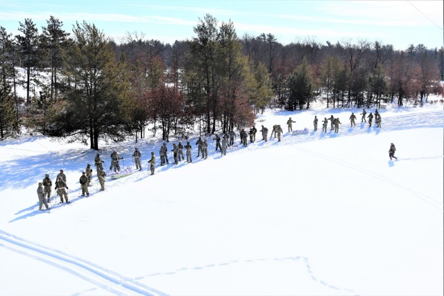 Students in Cold-Weather Operations Course class 21-04 complete field training pulling ahkio sleds of equipment on snowshoes Feb. 18, 2021, at a training area at Fort McCoy, Wis. Students complete many miles of ruck marching in the snow and cold...