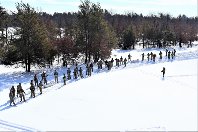 Students in Cold-Weather Operations Course class 21-04 complete field training pulling ahkio sleds of equipment on snowshoes Feb. 18, 2021, at a training area at Fort McCoy, Wis. Students complete many miles of ruck marching in the snow and cold...