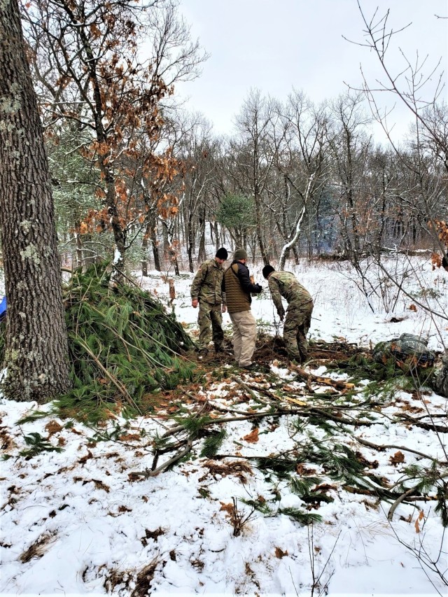 Students in Cold-Weather Operations Course class 21-05 conduct field training with improvised shelters, including with the one shown here, March 16, 2021, at a training area at Fort McCoy, Wis. CWOC students are trained on a variety of...