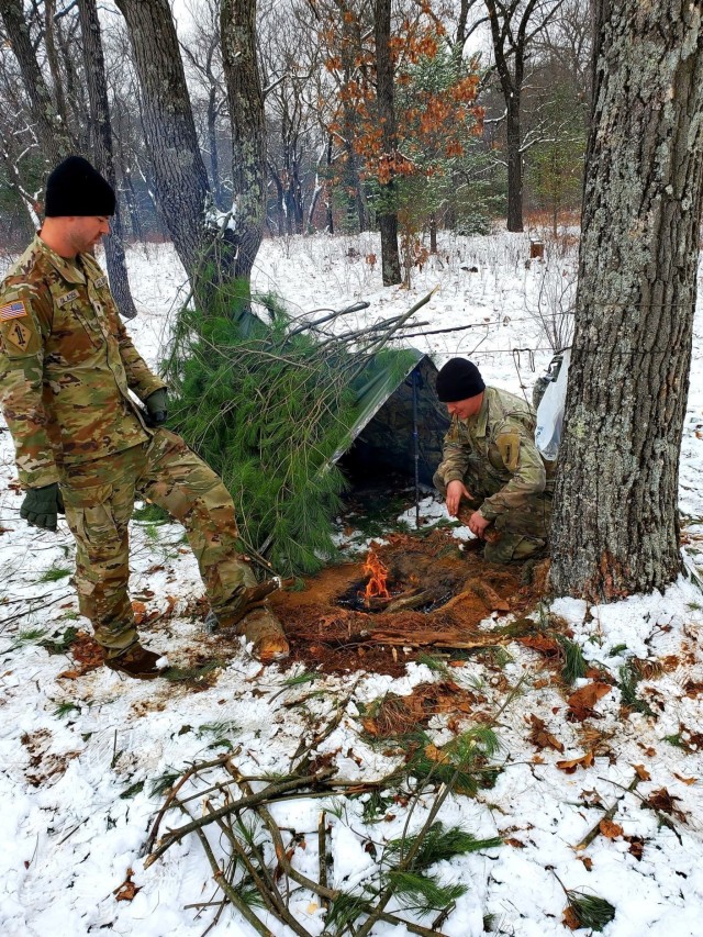 Students in Cold-Weather Operations Course class 21-05 conduct field training with improvised shelters, including with the one shown here, March 16, 2021, at a training area at Fort McCoy, Wis. CWOC students are trained on a variety of...