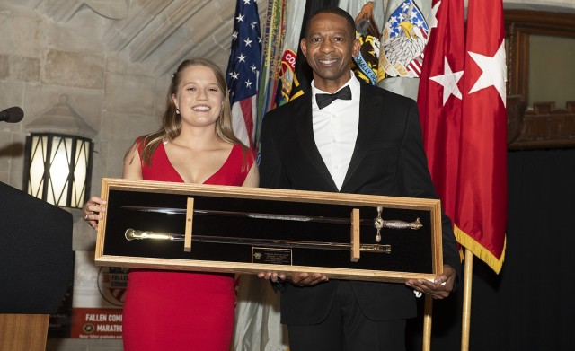 Class of 2021 Cadet and Class President Katarina Christianson presents a cadet sabre to guest speaker Command Sgt. Maj. Michael A. Crosby, command sergeant major of U.S. Army Futures Command, after he spoke during the 100th Night Banquet Friday.