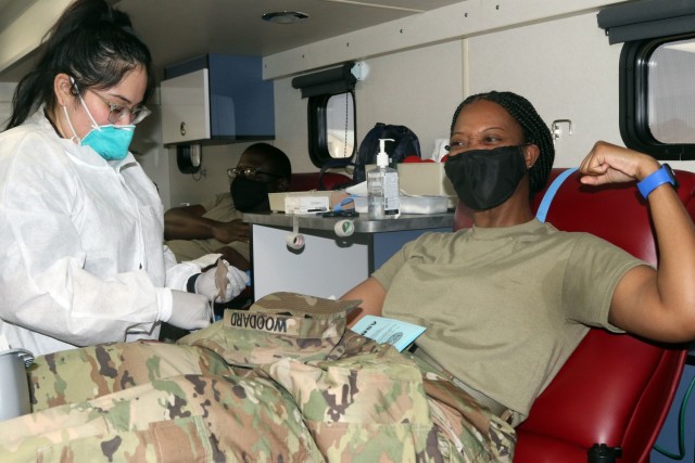 Sgt. 1st Class Shaundria Woodard, a donor assigned to 5th Armored Brigade, First Army Division West, raises her arm as an expression of courage with needles during a blood drive event on Fort Bliss, Texas, May 16, 2021. Blood drive events are important because they provide quality blood products for service members, veterans and their families in both peace and war. For 5th AR BDE, preparing Soldiers to go into harm’s way isn’t merely a cold, mechanical process; rather, it’s a dedication to individuals’ strengths and needs, focused on achieving the mission. (U.S. Army photo by Staff Sgt. John Onuoha, 5th Armored Brigade)