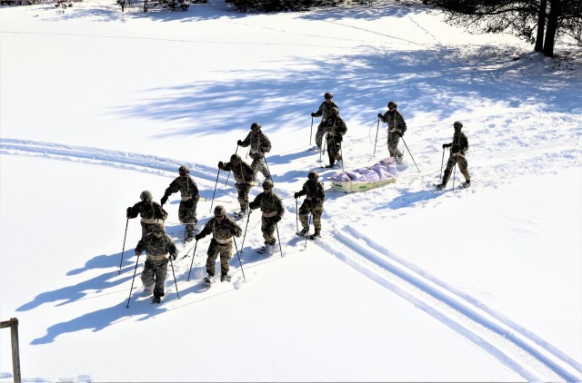 Students in Cold-Weather Operations Course class 21-04 complete field training pulling ahkio sleds of equipment on snowshoes Feb. 18, 2021, at a training area at Fort McCoy, Wis. Students complete many miles of ruck marching in the snow and cold...