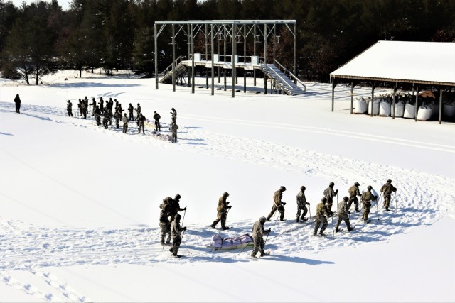 Students in Cold-Weather Operations Course class 21-04 complete field training pulling ahkio sleds of equipment on snowshoes Feb. 18, 2021, at a training area at Fort McCoy, Wis. Students complete many miles of ruck marching in the snow and cold...