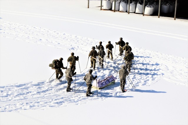 Students in Cold-Weather Operations Course class 21-04 complete field training pulling ahkio sleds of equipment on snowshoes Feb. 18, 2021, at a training area at Fort McCoy, Wis. Students complete many miles of ruck marching in the snow and cold...