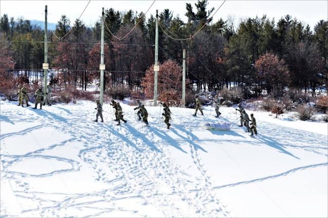Students in Cold-Weather Operations Course class 21-04 complete field training pulling ahkio sleds of equipment on snowshoes Feb. 18, 2021, at a training area at Fort McCoy, Wis. Students complete many miles of ruck marching in the snow and cold...