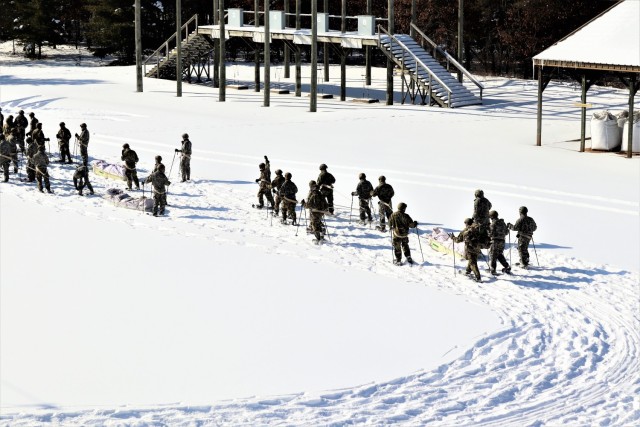Students in Cold-Weather Operations Course class 21-04 complete field training pulling ahkio sleds of equipment on snowshoes Feb. 18, 2021, at a training area at Fort McCoy, Wis. Students complete many miles of ruck marching in the snow and cold...