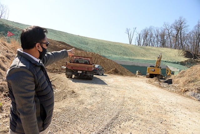 Chris Fernandez, Directorate of Plans, Training, Mobilization and Security operations and training specialist, points out some of the work being done to turn a 25-meter range into a 50-meter range, necessary for Law Enforcement Weapons Training...