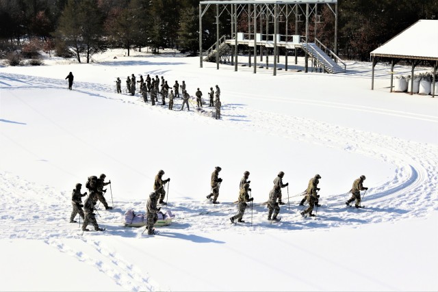 Students in Cold-Weather Operations Course class 21-04 complete field training pulling ahkio sleds of equipment on snowshoes Feb. 18, 2021, at a training area at Fort McCoy, Wis. Students complete many miles of ruck marching in the snow and cold...