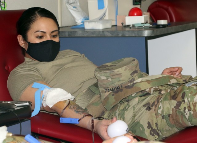 Cpl. Cassandra Zamora, a donor assigned to 5th Armored Brigade, First Army Division West, squeezes a ball to pump blood during a blood drive event on Fort Bliss, Texas, May 16, 2021. Blood drive events are important because they provide quality...