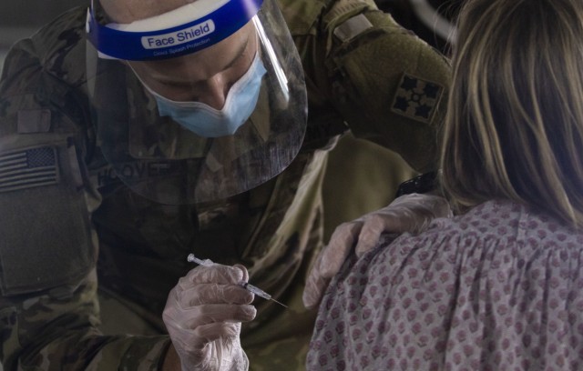 U.S. Army Spc. Jeb Hoover, assigned to the 4th Infantry Division, Fort Carson, Colo., vaccinates a California community member at the walk-up vaccination site at California State University Los Angeles in California, Feb. 20, 2021. U.S. Northern Command, through U.S. Army North, remains committed to providing continued, flexible Department of Defense support to the Federal Emergency Management Agency as part of the whole-of-government response to COVID-19. (U.S. Army photo by Pfc. Garrison Waites/5th Mobile Public Affairs Detachment)