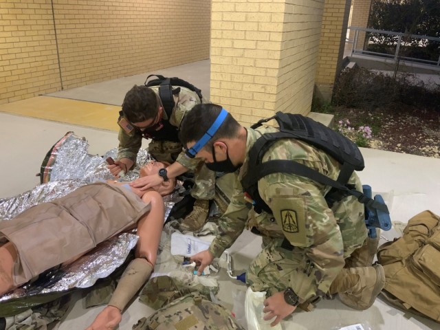 Sgt. Carter McCall (left) and CPT Alexander Goncalves (right) provide simulated point of injury care during Tactical Combat Medical Care’s trauma lane scenarios on Joint Base San Antonio-Fort Sam Houston, Texas, March 18, 2021.