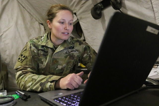 Maj. Kira C. Weyrauch, intelligence planner, Headquarters and Headquarters Battalion, 4th Infantry Division, reads over a fragmentary order in a tactical operations center during a warfighter exercise. The Commercial Solutions for Classified capabilities developed by the C5ISR Center aligns with the Army’s vision of creating an environment where approved personnel can access classified applications and data from anywhere. 