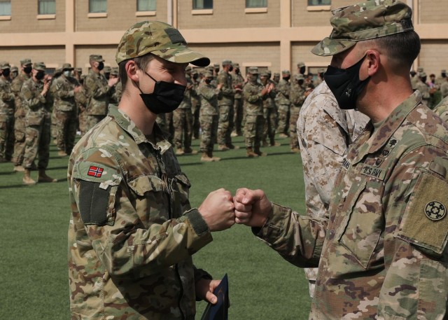 Norwegian Army 1st Lt. Havard Boge fist bumps Army Reserve Brig. Gen. Justin Swanson, the commanding general of the 310th Sustainment Command (Expeditionary) during the March 21, 2021 recognition ceremony at Camp Arifjan, Kuwait, for the 328 U.S....