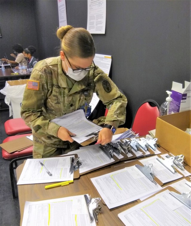 Lyster Army Health Clinic team members prep paperwork for Tier 2 beneficiaries awaiting their COVID Vaccination. 
