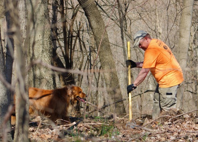 Army civilian Eric Schweighauser, safety manager, 1st Theater Sustainment Command, prepares a  trail with his dog Bailey at Buttermilk Falls in Brandenburg, Kentucky, March 20, 2021. Schweighauser is a founding member of Kentucky Mountain Bike Association, Lincoln Trails and together they help develop and maintain mountain bike trails in the local area. (U.S. Army photo by Barbara Gersna, Public Affairs)