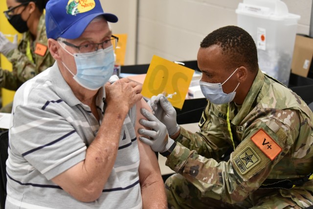 PV2 Anoumou Game, a 68C Practical Nursing Specialist student assigned to the 264th Medical Battalion, 32nd Medical Brigade, MEDCoE, administers the COVID-19 vaccine to a patient. PV2 Game completed Phase 1 of his Advanced Individual Training and is assisting the Brooke Army Medical Center inoculating patients.