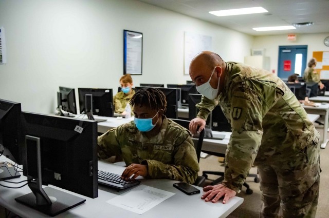 Sgt. Chris Marra, instructor for the Information Technology Training Center (ITTC), National Guard Professional Education Center, observes Pvt. Makyle Stepps, an RSP recruit awaiting basic training, during the Interactive War Games cyber...