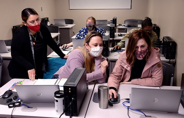 Military Health System (MHS) Genesis trainer Joyce Ruano works with Munson Army Health Center Pharmacy Pharmacists Alexis Robinson and Meghan Merriss on use of the new patient information system March 23 in the MAHC learning lab. Pharmacy personnel were learning how to navigate the electronic records system, how to enter prescriptions and more during the training. The new system launches April 24 at MAHC. Photo by Prudence Siebert/Fort Leavenworth Lamp