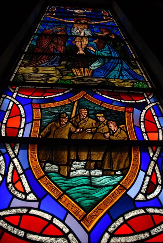 Stained glass windows in Pioneer Chapel feature a Biblical scene in the center with a related symbol or scene of contemporary life below and the Lamp of Knowledge above. This window depicts sacrifice — Christ on the cross and Lieutenants George...