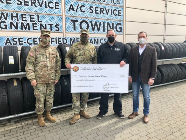 WIESBADEN, Germany -- Steffen Schwenke, Auto Skills recreation assistant, receives his check from Col. Mario Washington, garrison commander, Command Sgt. Maj. Christopher Truchon and Scott Mowry, deputy to the garrison commander, for outstanding...