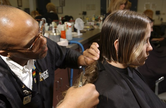 Female U.S. Navy recruits get their first haircut at the Navy Exchange barbershop in 2003. Recruits used to get haircuts within the first couple of days upon arrival to boot camp. 