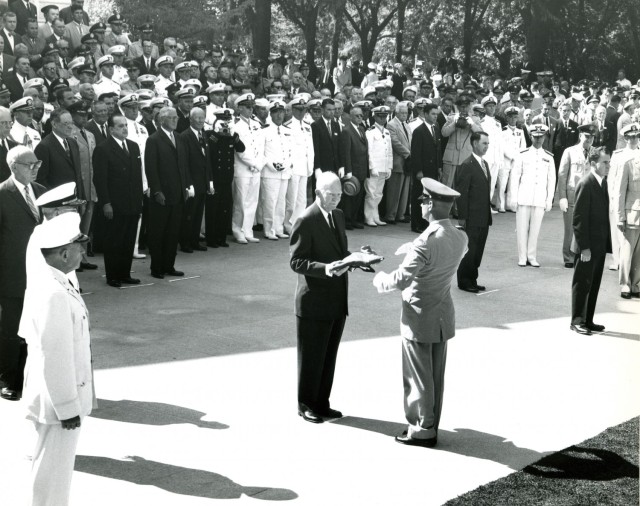 Honoring the fallen: Kouma hands the folded American flag to President Einsenhower in 1958 to conclude the ceremony interring two Unknown Soldiers.