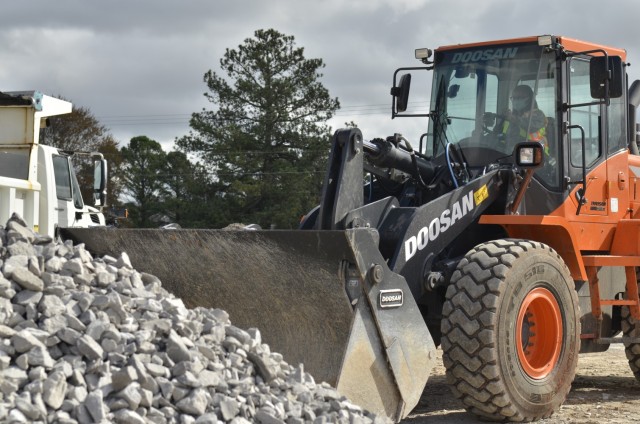 Nilka Goodwin, engineering equipment operator, Directorate of Public Works, uses a bucket truck to load gravel from the DPW Roads and Grounds parking lot. Goodwin is the only female engineering equipment operator in the Directorate of Public Works Roads and Grounds Division, and the only woman known to have taken on the job at Fort Campbell.