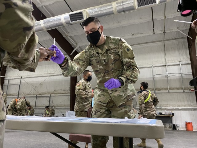 Spc. Andrew Running, a medic with Headquarters and Headquarters Company, 1st General Support Aviation Battalion, 168th Aviation Regiment (GSAB), collects samples for the BINAX test, March 16, 2021 at North Fort Hood, Texas. The Soldiers of Task Force Phoenix have been tested frequently for COVID-19 during pre-deployment training at the fort. (U.S. Army National Guard photo by Sgt. 1st Class Ryan Sheldon)